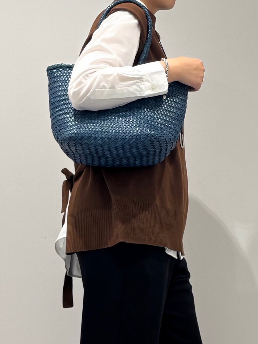 ブルー系のトートバッグ、ブラック系のその他パンツ、ホワイト系のシャツ/ブラウスを着用したレディースの秋コーディネートの6枚目の写真