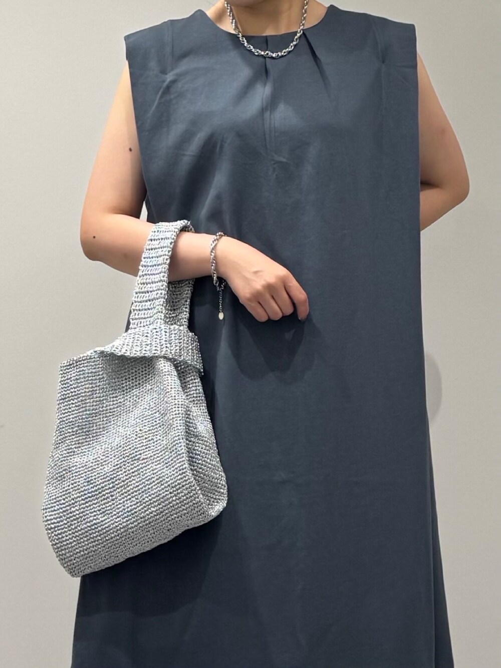 シルバー系のかごバッグ、ブラック系のサンダル、ブルー系のワンピースを着用したレディースの夏コーディネートの8枚目の写真