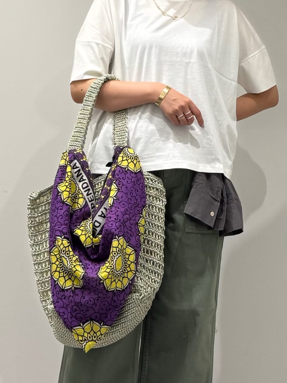 ゴールド系のかごバッグ、グレー系のシャツ/ブラウス、グリーン系のその他パンツを着用したレディースの夏コーディネートの7枚目の写真