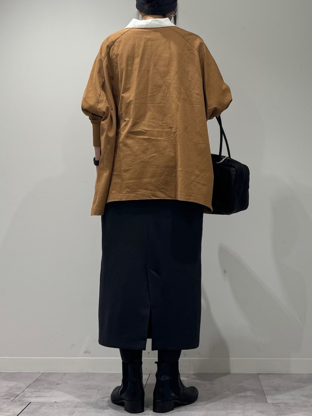 ブラック系のボストンバッグ、ベージュ系のTシャツ/カットソー、シルバー系のネックレスを着用したレディースの冬コーディネートの4枚目の写真