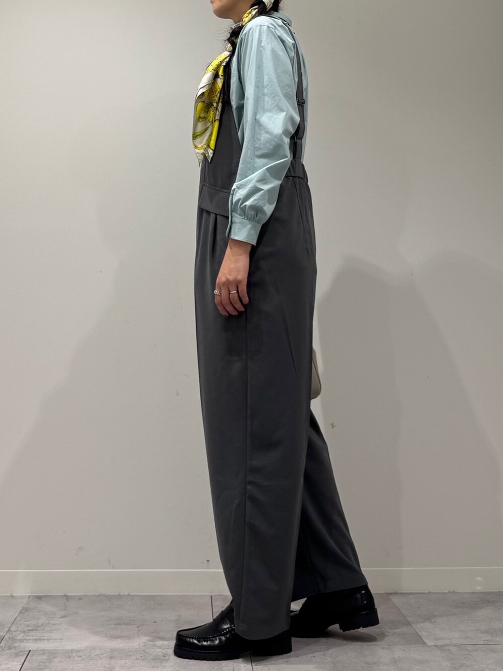 ブラック系のローファー、グレー系のサロペット/オーバーオール、グレー系のボストンバッグを着用したレディースの秋コーディネートの5枚目の写真