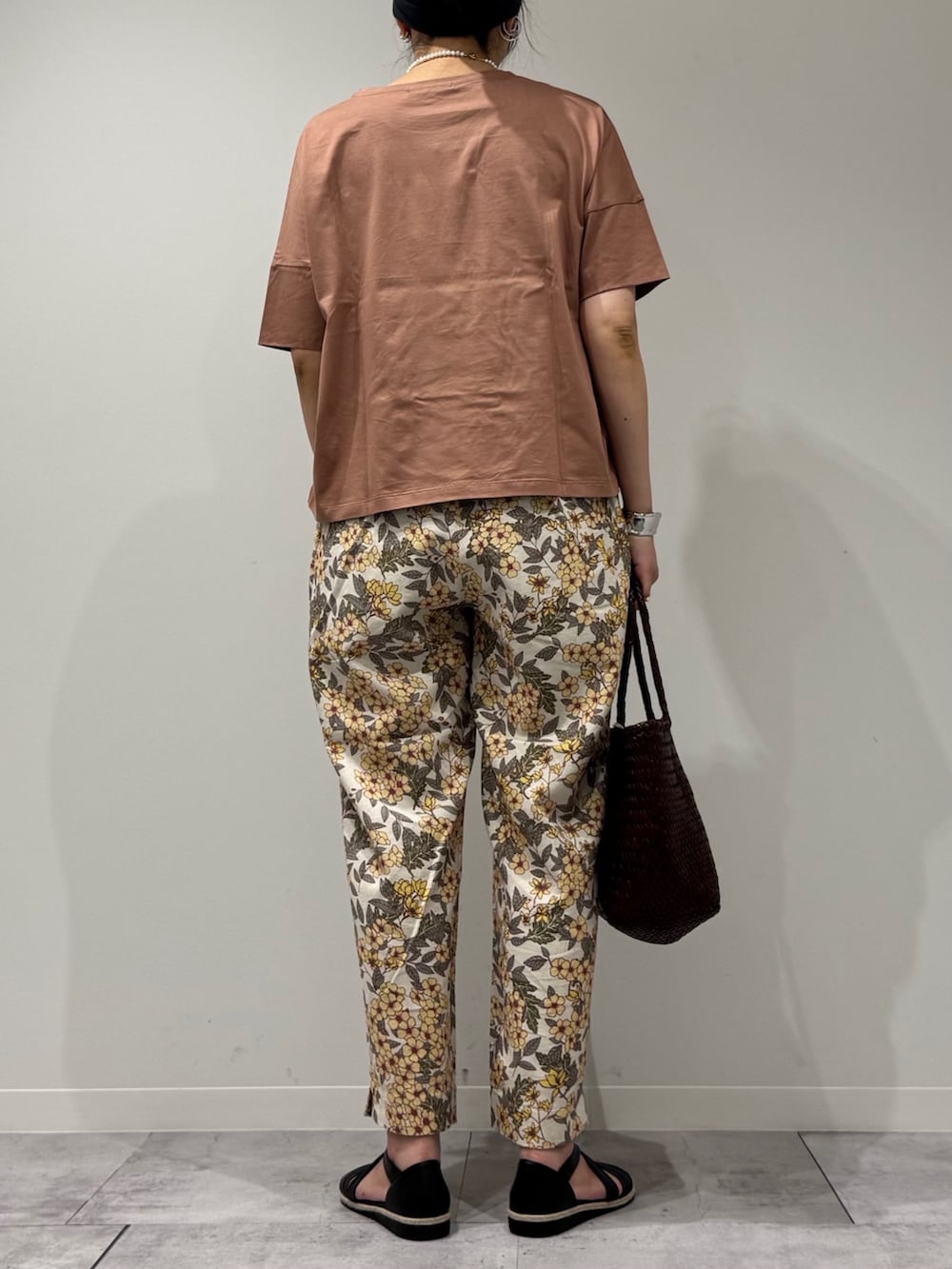 ブラウン系のトートバッグ、イエロー系のその他パンツ、ブラック系のサンダルを着用したレディースの春コーディネートの4枚目の写真