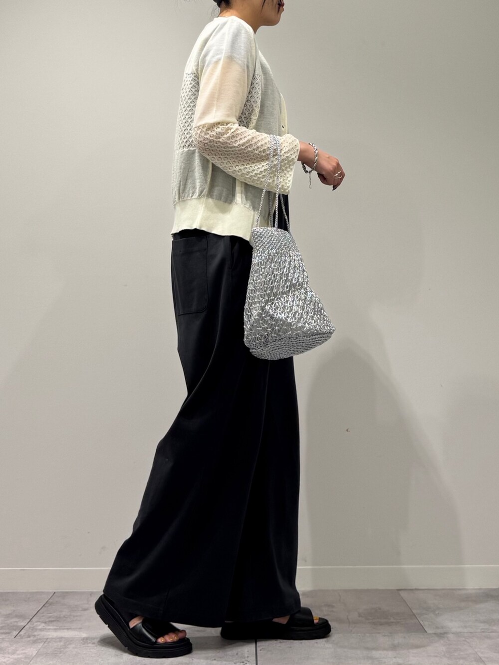 シルバー系のかごバッグ、グレー系のサロペット/オーバーオール、ブラック系のサンダルを着用したレディースの秋コーディネートの2枚目の写真