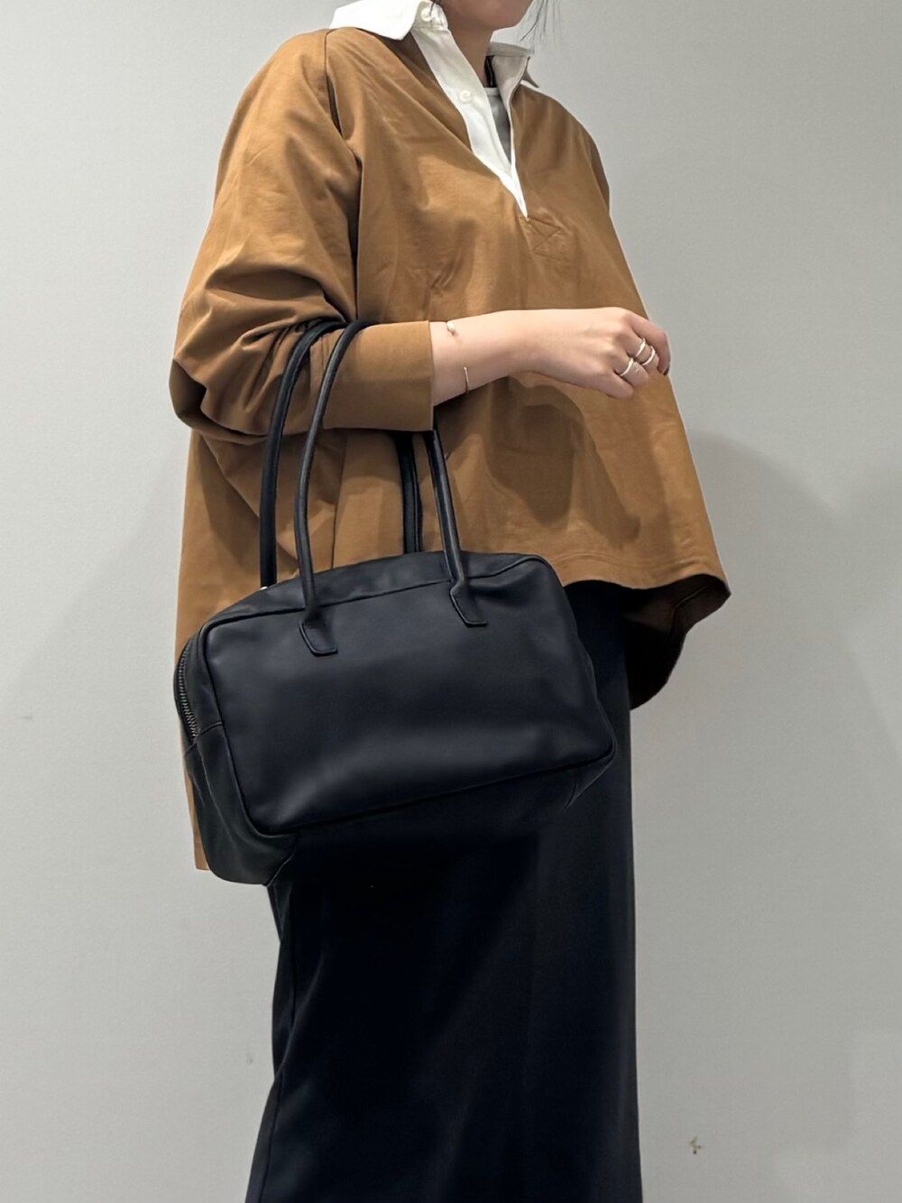 ブラック系のボストンバッグ、ベージュ系のTシャツ/カットソー、シルバー系のネックレスを着用したレディースの冬コーディネートの8枚目の写真