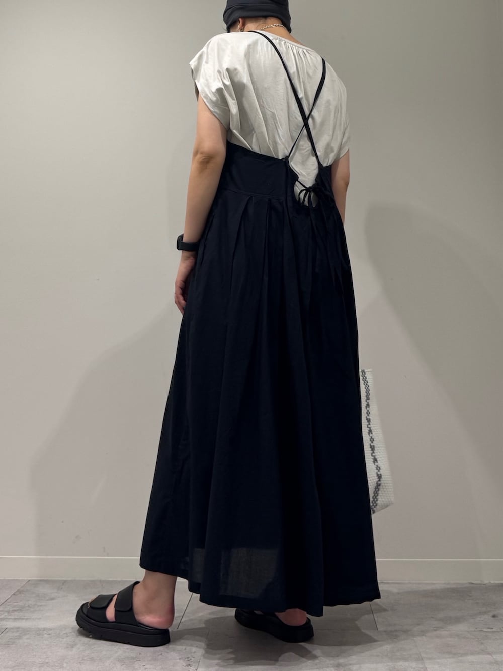 ブラック系のワンピース、ホワイト系のかごバッグ、ブラック系のサンダルを着用したレディースの夏コーディネートの4枚目の写真