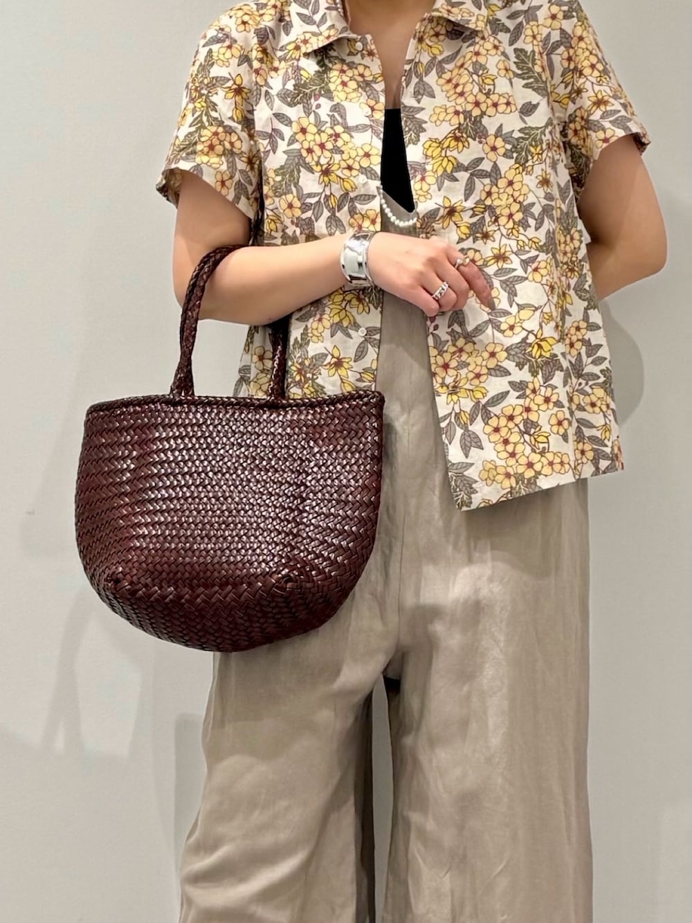 ブラウン系のトートバッグ、ベージュ系のサロペット/オーバーオール、ブラック系のサンダルを着用したレディースの春コーディネートの8枚目の写真