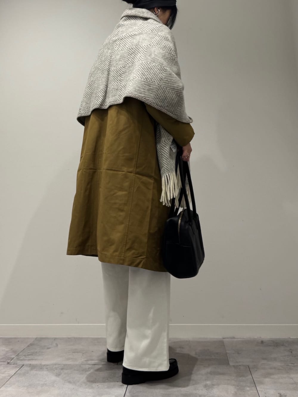 ブラック系のボストンバッグ、ベージュ系のダウンジャケット/コート、ホワイト系のデニムパンツを着用したレディースの冬コーディネートの3枚目の写真