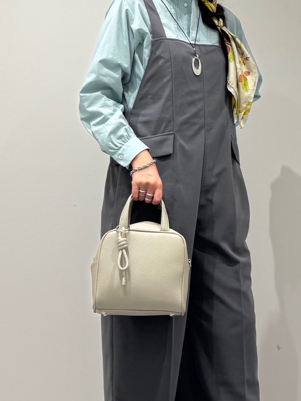 ブラック系のローファー、グレー系のサロペット/オーバーオール、グレー系のボストンバッグを着用したレディースの秋コーディネートの7枚目の写真