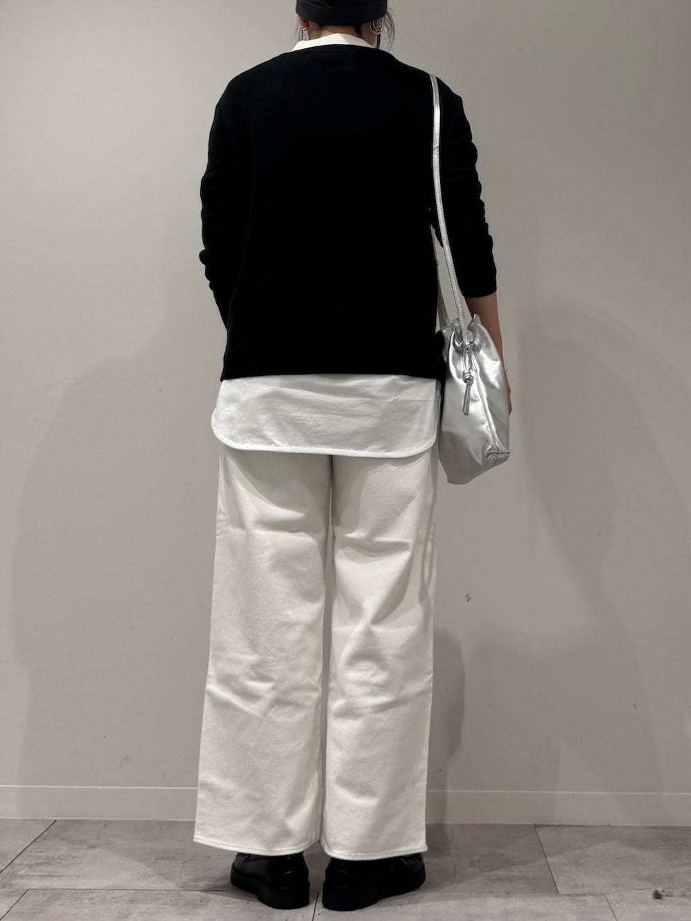 シルバー系のショルダーバッグ、ホワイト系のデニムパンツ、ブラック系のローファーを着用したレディースの冬コーディネートの3枚目の写真