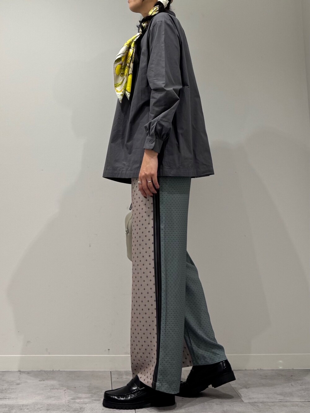 グレー系のボストンバッグ、ベージュ系のその他パンツ、ブラック系のローファーを着用したレディースの秋コーディネートの5枚目の写真