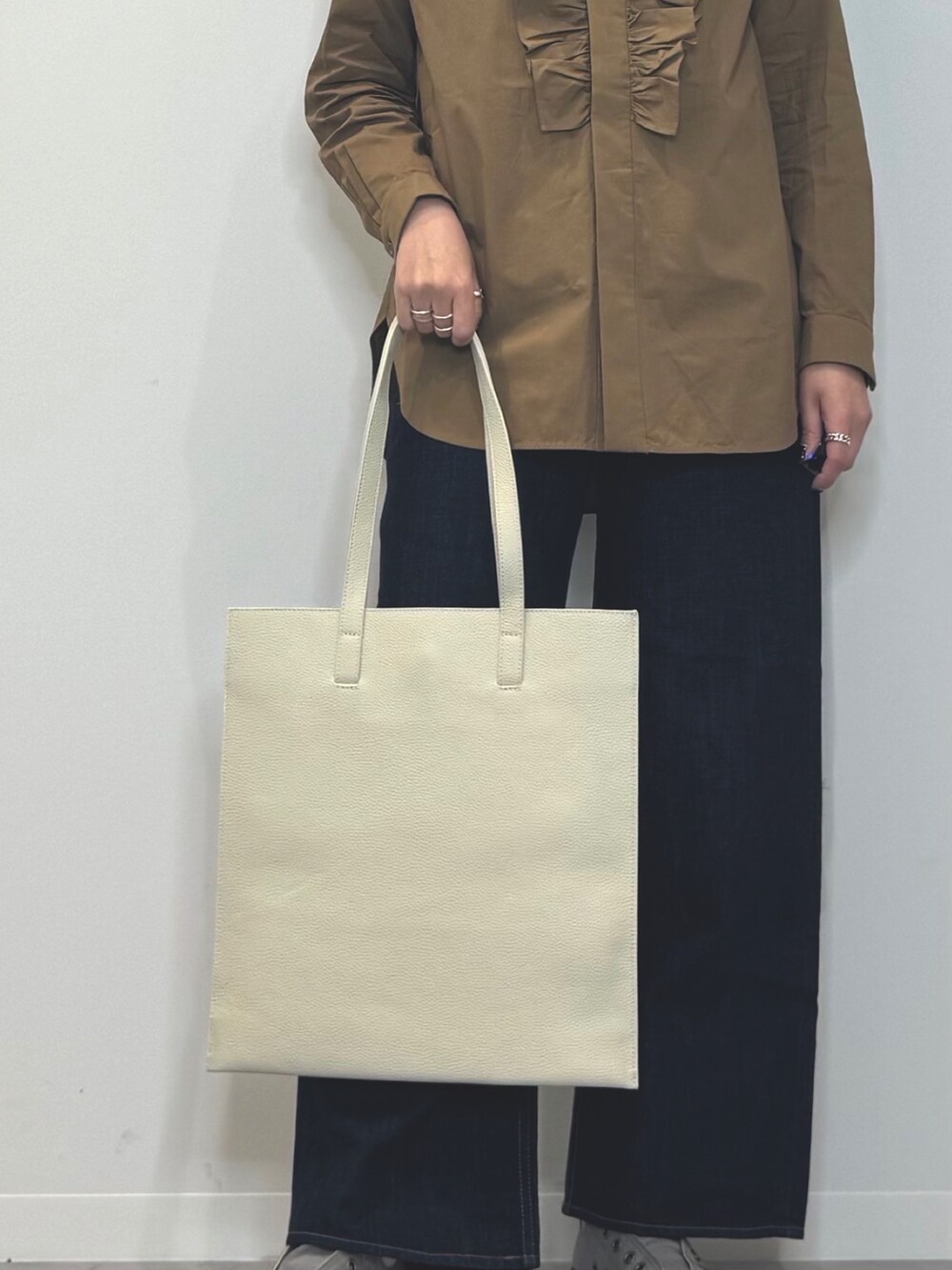 ホワイト系のトートバッグ、ブルー系のデニムパンツ、ブラウン系のシャツ/ブラウスを着用したレディースの春コーディネートの8枚目の写真