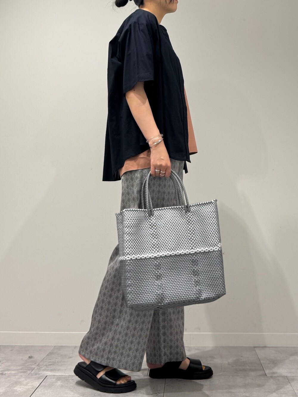 ピンク系のTシャツ/カットソー、シルバー系のかごバッグ、ベージュ系のその他パンツを着用したレディースの春コーディネートの2枚目の写真