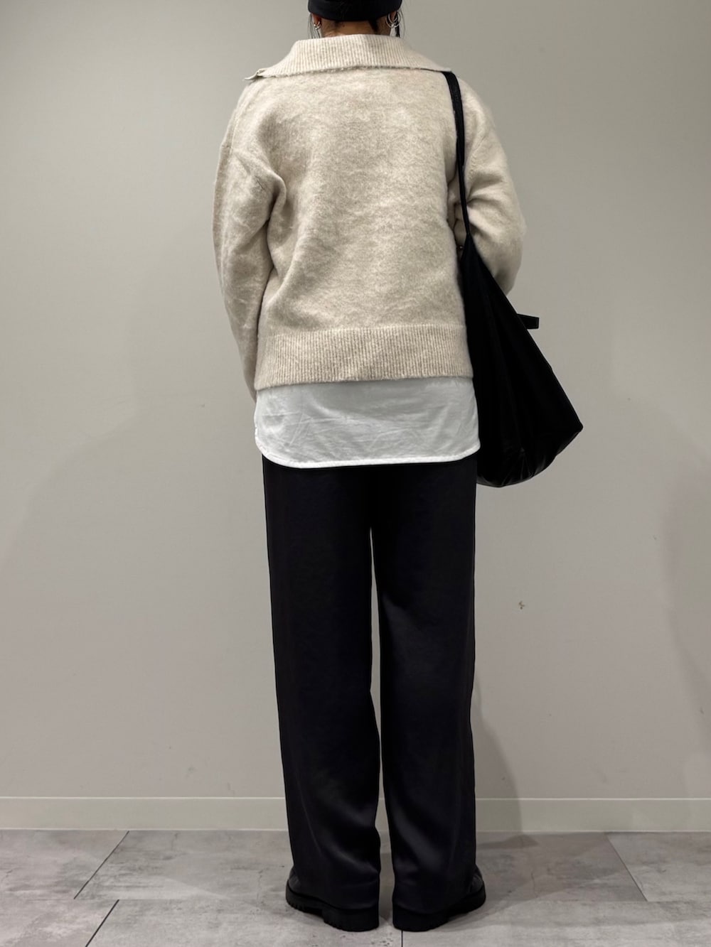 ブラック系のトートバッグ、ホワイト系のニット/セーター、ホワイト系のTシャツ/カットソーを着用したレディースの冬コーディネートの3枚目の写真
