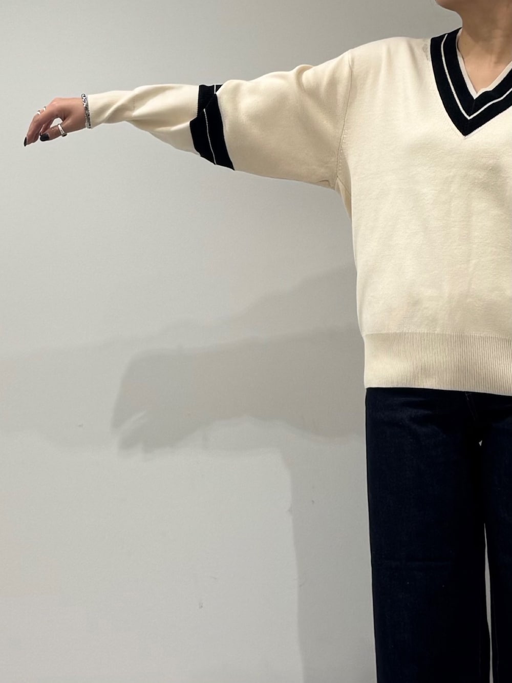 パープル系のトートバッグ、ブルー系のデニムパンツ、ブラック系のローファーを着用したレディースの冬コーディネートの6枚目の写真