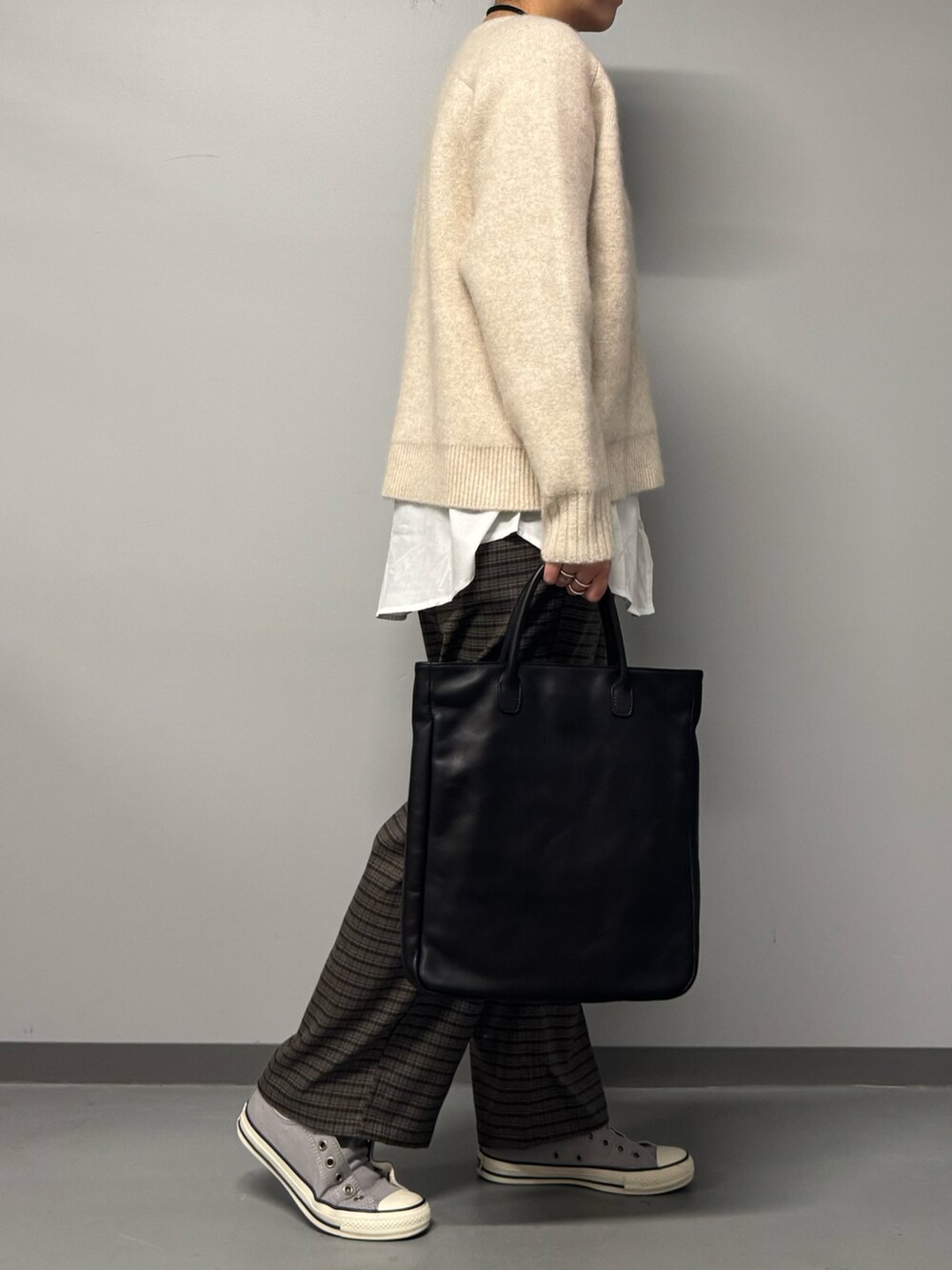 ベージュ系のニット/セーター、ブラウン系のその他パンツ、ブラック系のトートバッグを着用したレディースの冬コーディネートの4枚目の写真
