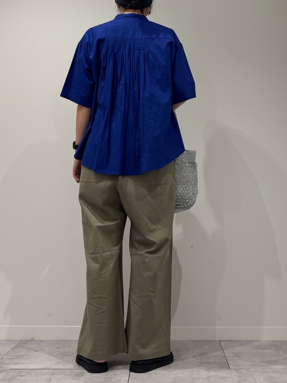 シルバー系のかごバッグ、グリーン系のサロペット/オーバーオール、ブルー系のシャツ/ブラウスを着用したレディースの夏コーディネートの3枚目の写真