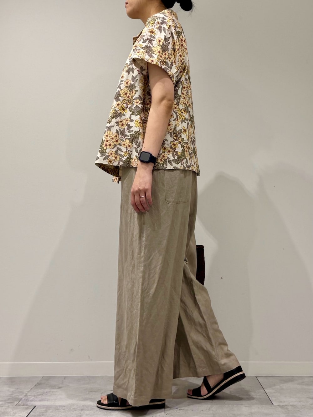 ブラウン系のトートバッグ、ベージュ系のサロペット/オーバーオール、ブラック系のサンダルを着用したレディースの春コーディネートの6枚目の写真