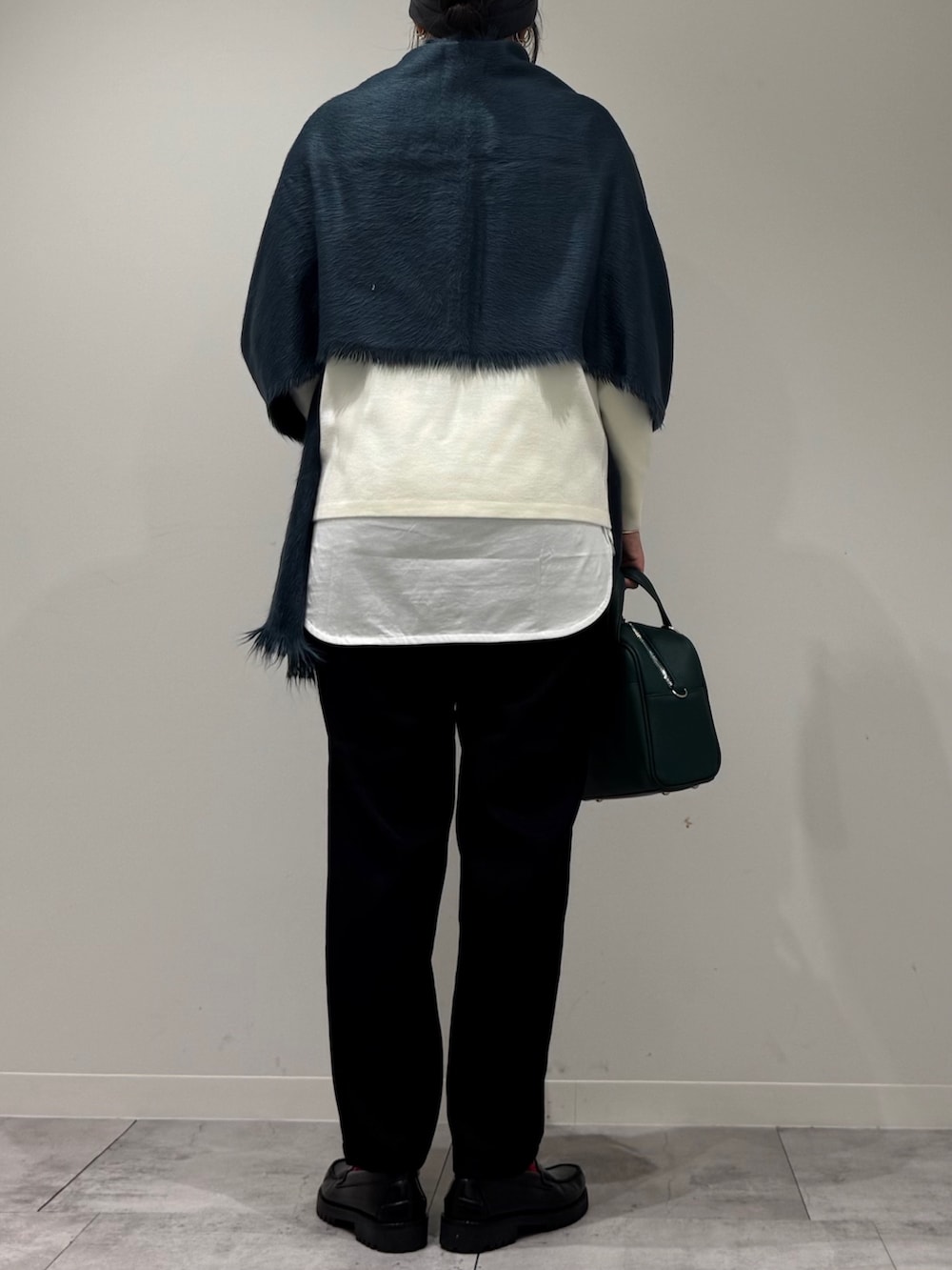 グリーン系のボストンバッグ、ブラック系のその他パンツ、ブラック系のローファーを着用したレディースの冬コーディネートの4枚目の写真