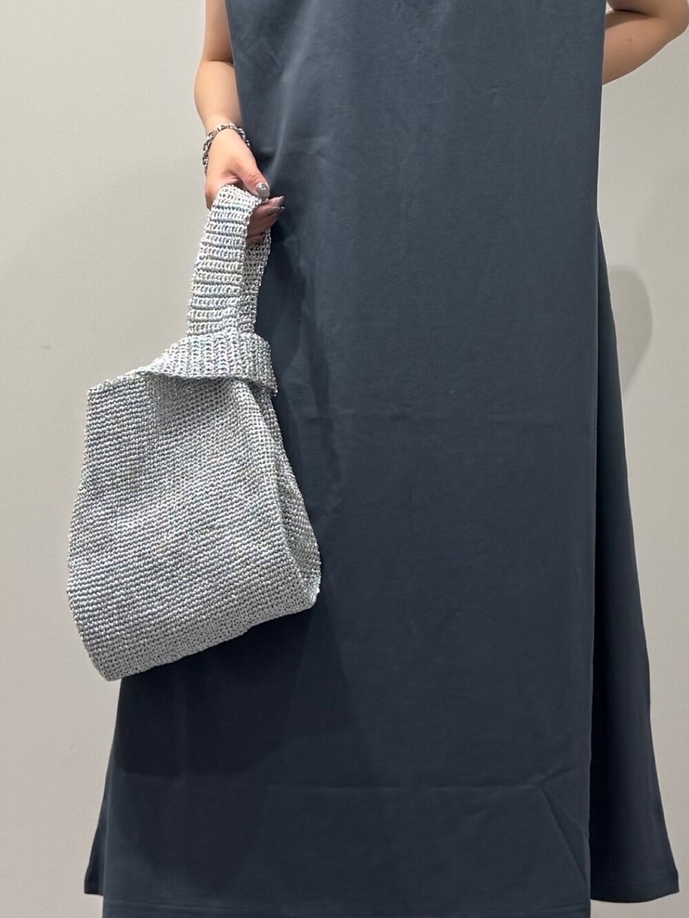 シルバー系のかごバッグ、ブラック系のサンダル、ブルー系のワンピースを着用したレディースの夏コーディネートの7枚目の写真