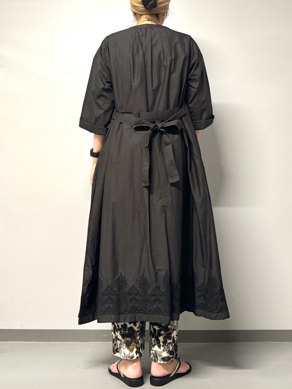 ブラック系のワンピース、ブラック系のサンダル、ホワイト系のTシャツ/カットソーを着用したレディースの夏コーディネートの2枚目の写真