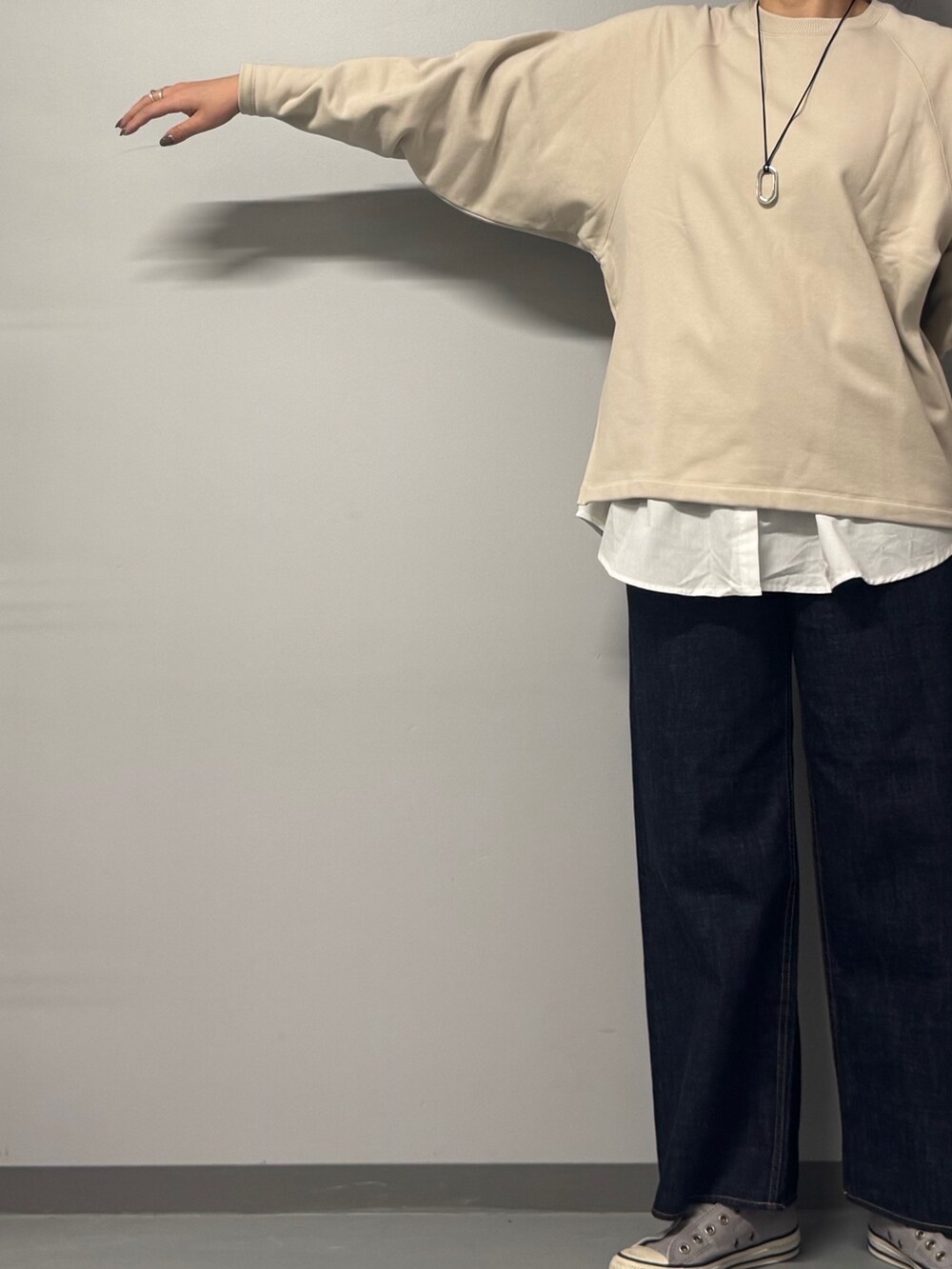 ベージュ系のスウェット、ブルー系のデニムパンツ、グレー系のトートバッグを着用したレディースの冬コーディネートの8枚目の写真
