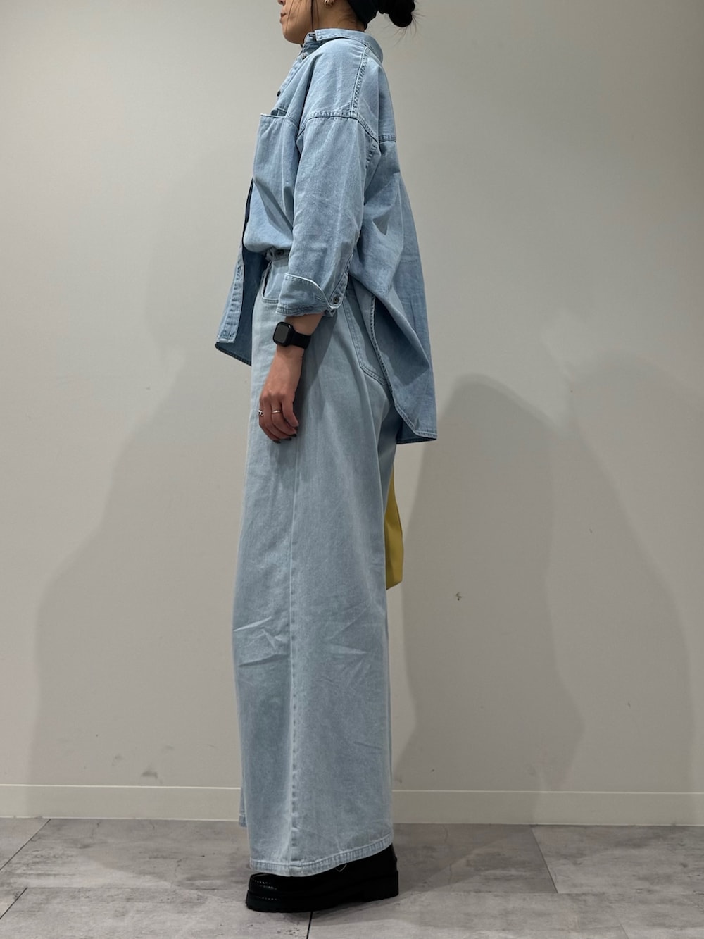 イエロー系のショルダーバッグ、ブルー系のデニムパンツ、ブラック系のローファーを着用したレディースの春コーディネートの5枚目の写真