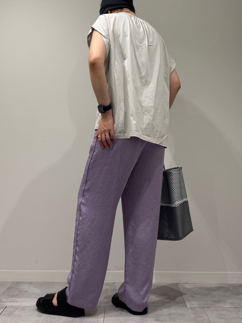 グレー系のTシャツ/カットソー、シルバー系のかごバッグ、ブラック系のサンダルを着用したレディースの夏コーディネートの4枚目の写真