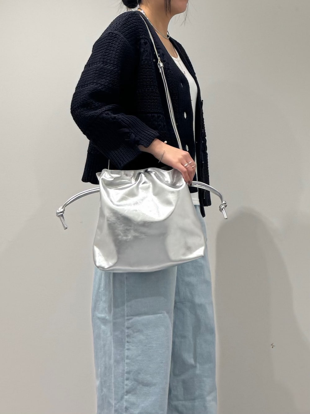 シルバー系のショルダーバッグ、ブルー系のデニムパンツ、ホワイト系のタンクトップを着用したレディースの春コーディネートの9枚目の写真