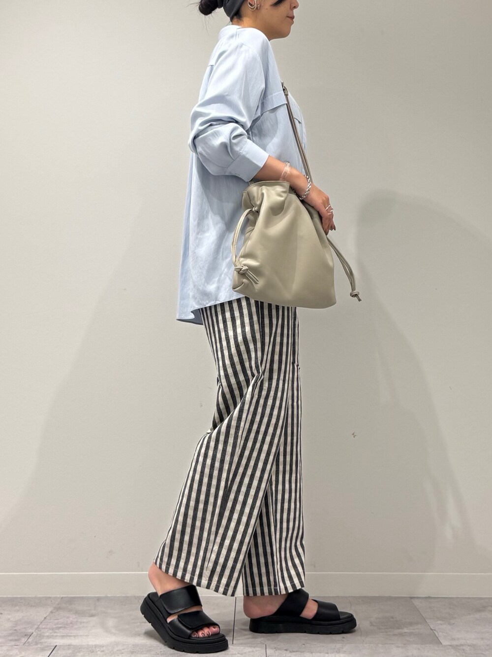 ベージュ系のショルダーバッグ、ブラック系のその他パンツ、ブラック系のサンダルを着用したレディースの秋コーディネートの2枚目の写真