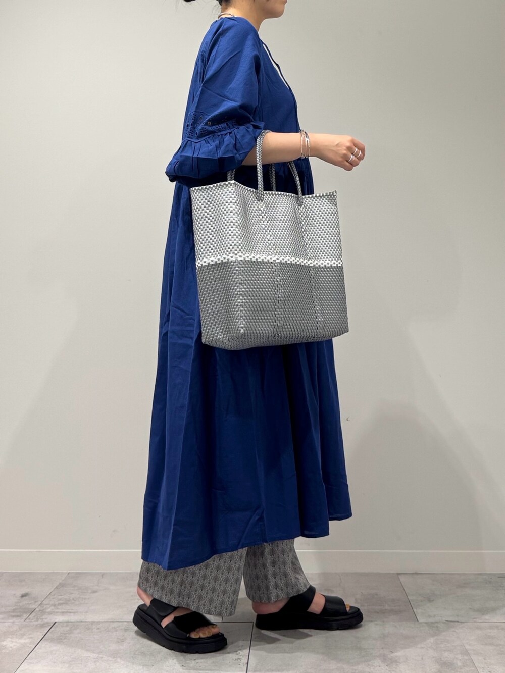 シルバー系のかごバッグ、ブラック系のサンダル、ベージュ系のその他パンツを着用したレディースの春コーディネートの2枚目の写真