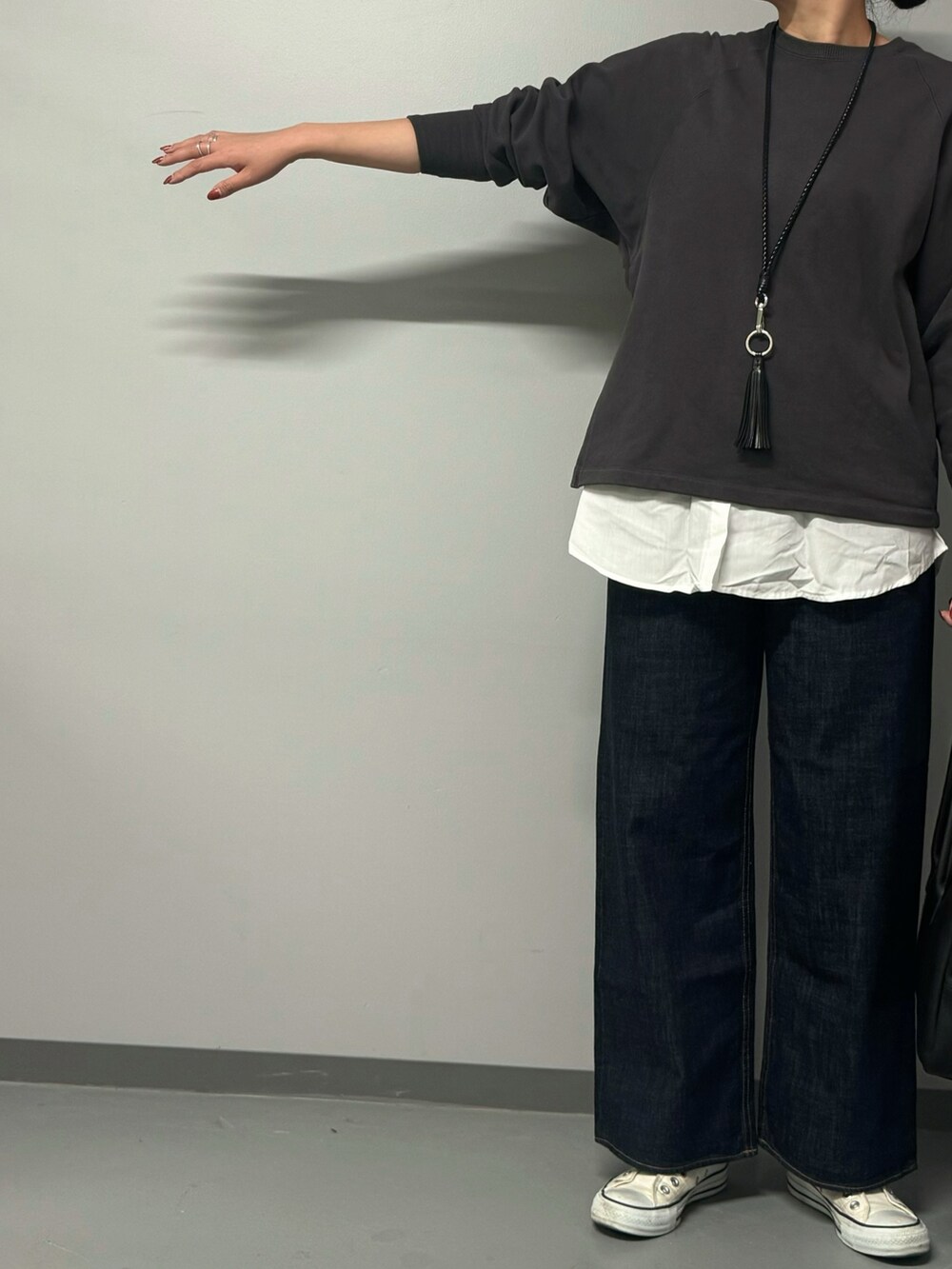 グレー系のスウェット、ブルー系のデニムパンツ、ブラック系のボストンバッグを着用したレディースの秋コーディネートの5枚目の写真