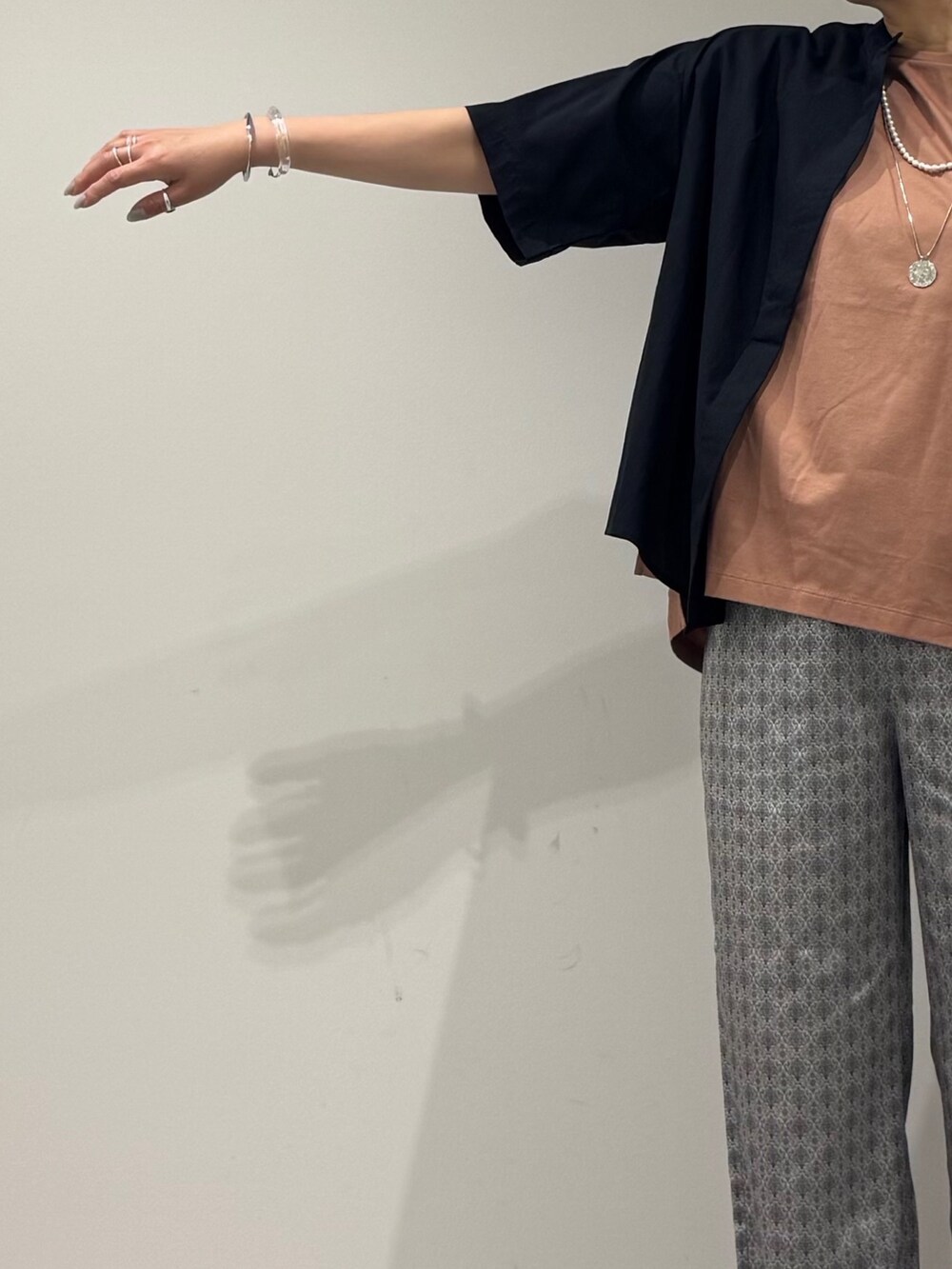 ピンク系のTシャツ/カットソー、シルバー系のかごバッグ、ベージュ系のその他パンツを着用したレディースの春コーディネートの7枚目の写真