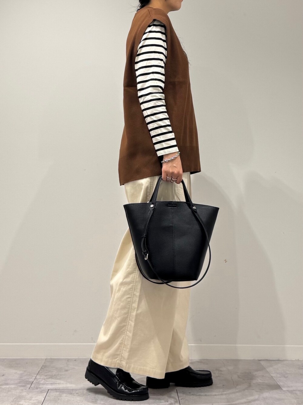 ブラック系のトートバッグ、ブラック系のTシャツ/カットソー、ホワイト系のその他パンツを着用したレディースの冬コーディネートの2枚目の写真