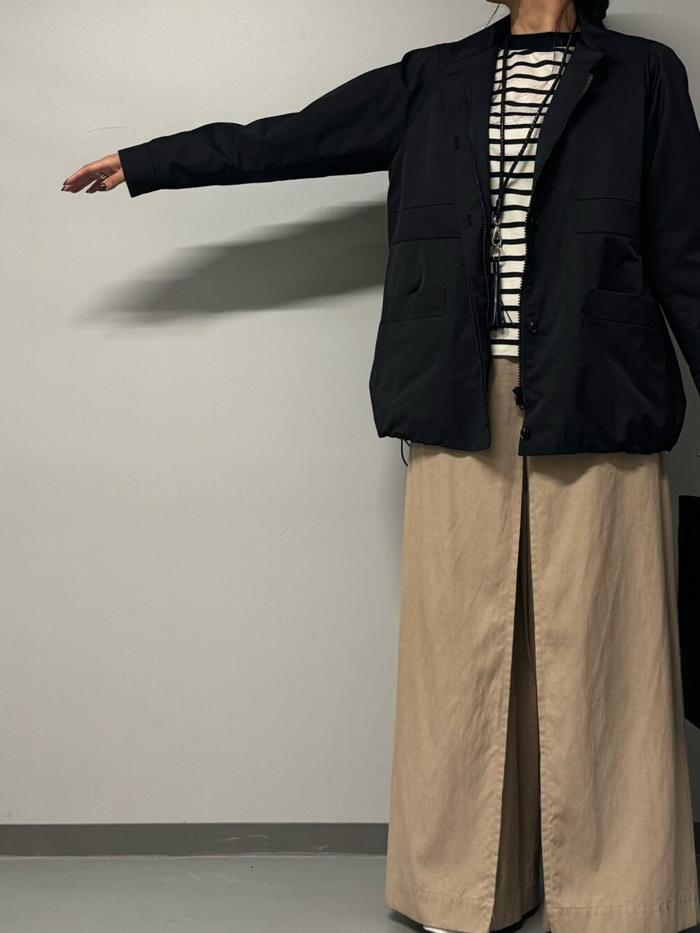 ブラック系のトートバッグ、ブラック系のブルゾン、ブラック系のTシャツ/カットソーを着用したレディースの秋コーディネートの6枚目の写真