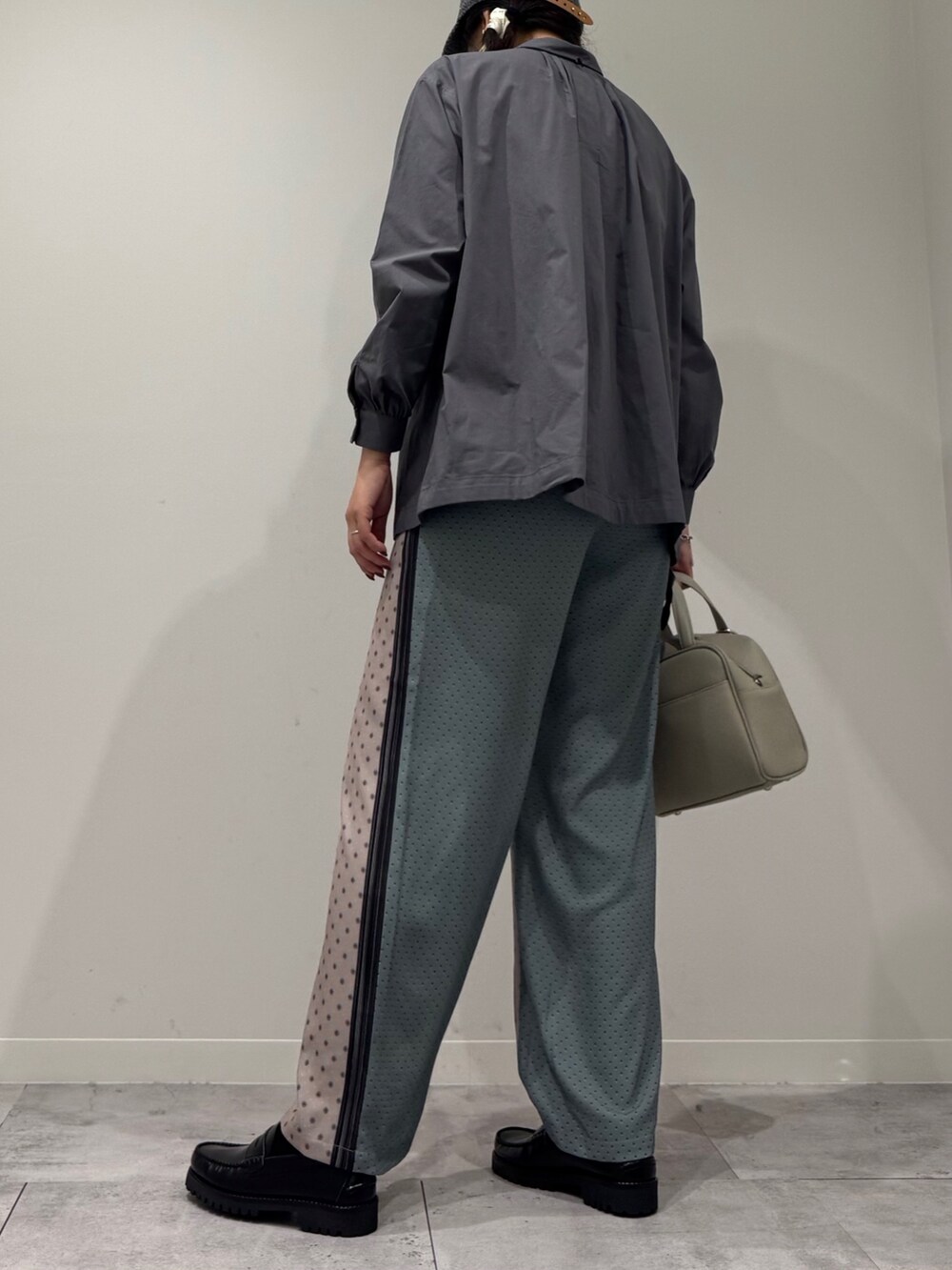 グレー系のボストンバッグ、ベージュ系のその他パンツ、ブラック系のローファーを着用したレディースの秋コーディネートの4枚目の写真