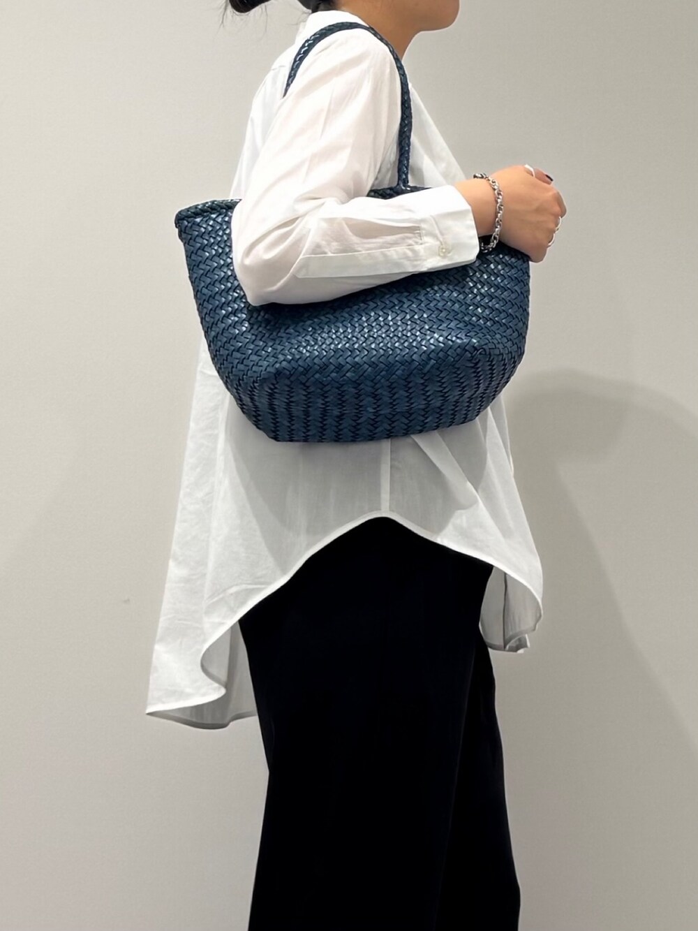 ブルー系のトートバッグ、ブラック系のその他パンツ、ホワイト系のシャツ/ブラウスを着用したレディースの秋コーディネートの8枚目の写真