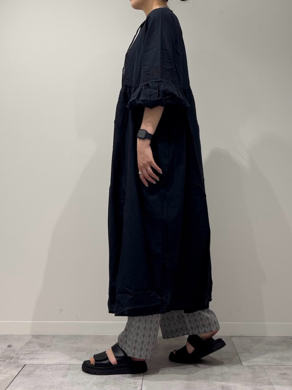 ブラック系のワンピース、シルバー系のかごバッグ、ブラック系のサンダルを着用したレディースの秋コーディネートの6枚目の写真