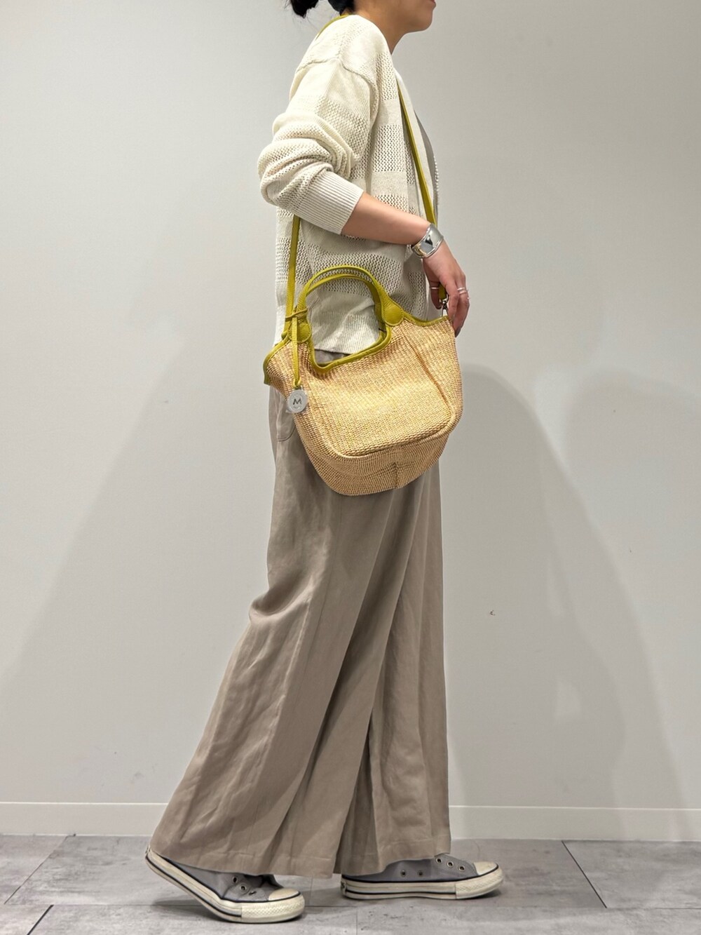 ベージュ系のサロペット/オーバーオール、ホワイト系のカーディガン/ボレロ、ベージュ系のかごバッグを着用したレディースの春コーディネートの2枚目の写真