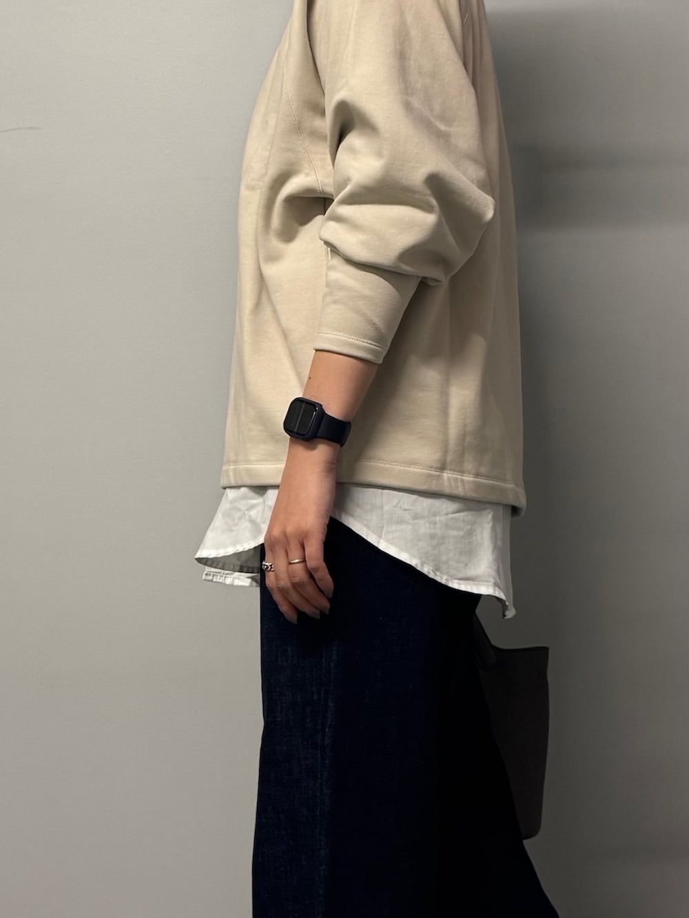 ベージュ系のスウェット、ブルー系のデニムパンツ、グレー系のトートバッグを着用したレディースの冬コーディネートの4枚目の写真