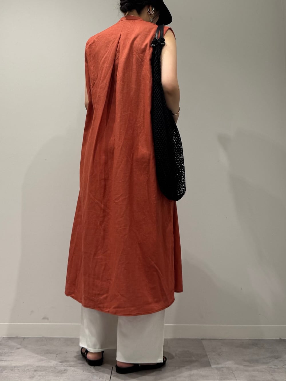 レッド系のワンピース、ホワイト系のデニムパンツ、ブラック系のサンダルを着用したレディースの夏コーディネートの2枚目の写真