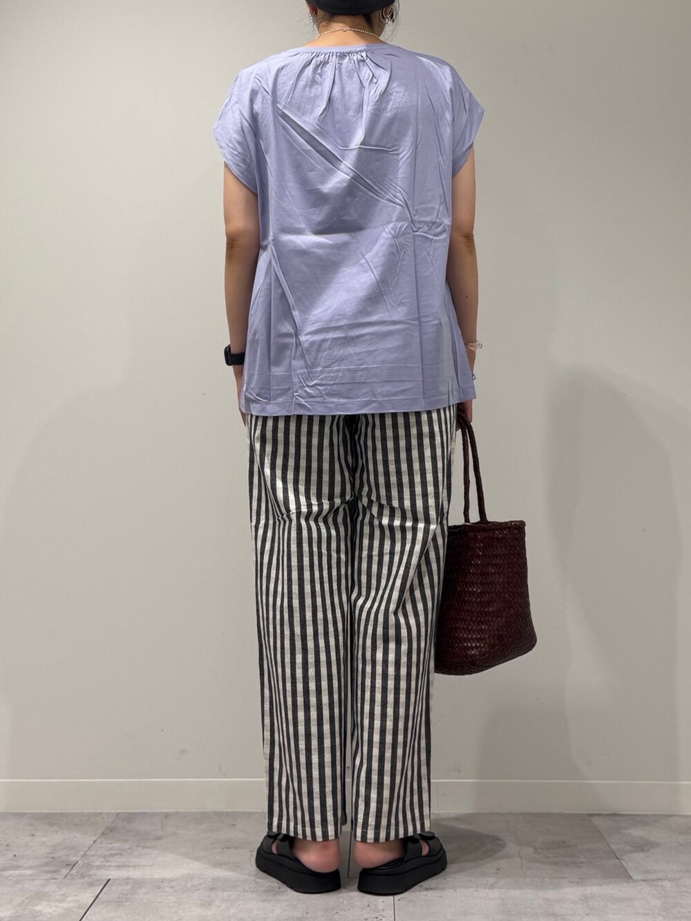 ブラウン系のトートバッグ、ブラック系のその他パンツ、ブラック系のサンダルを着用したレディースの秋コーディネートの3枚目の写真