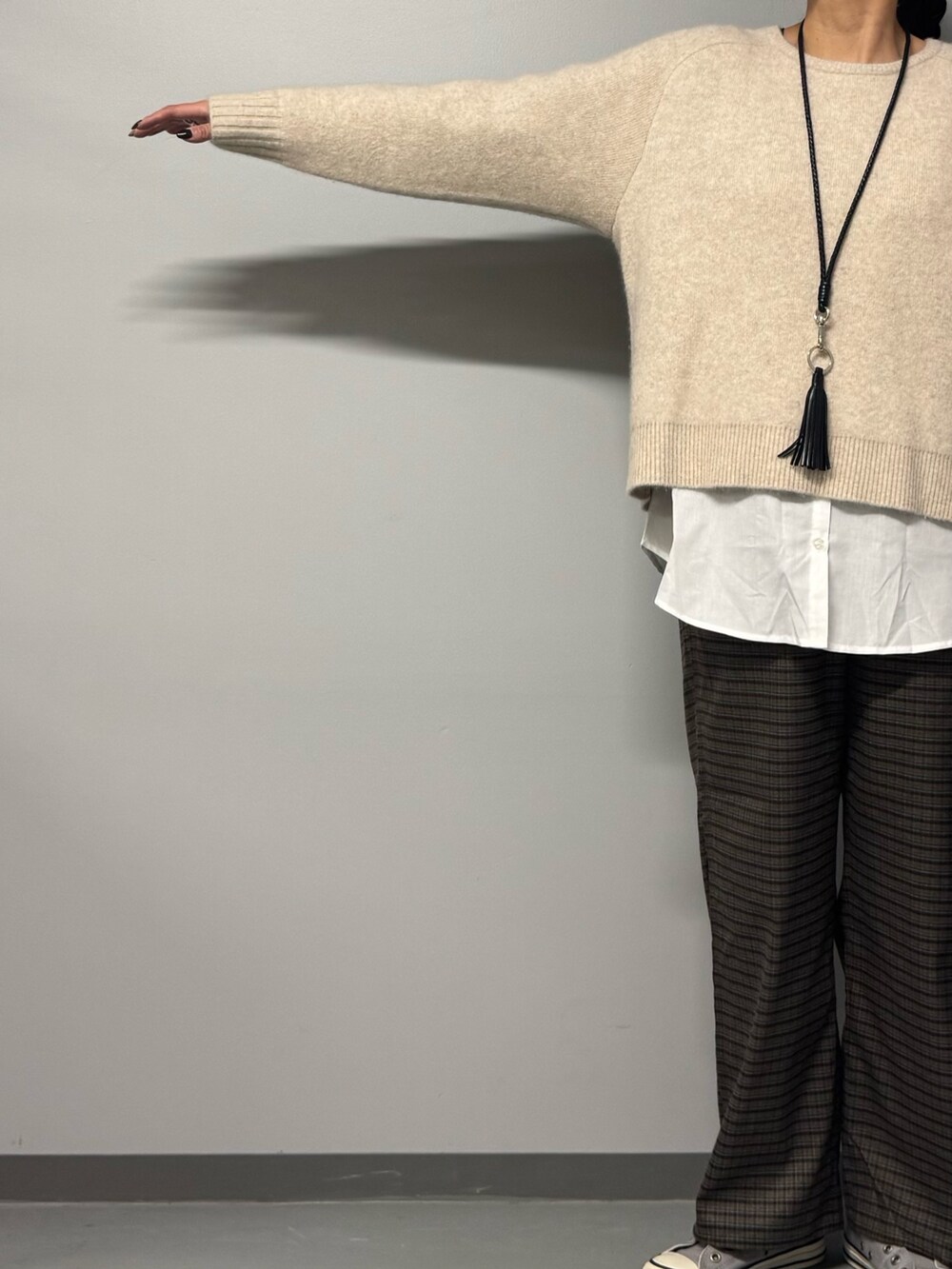 ベージュ系のニット/セーター、ブラウン系のその他パンツ、ブラック系のトートバッグを着用したレディースの冬コーディネートの3枚目の写真