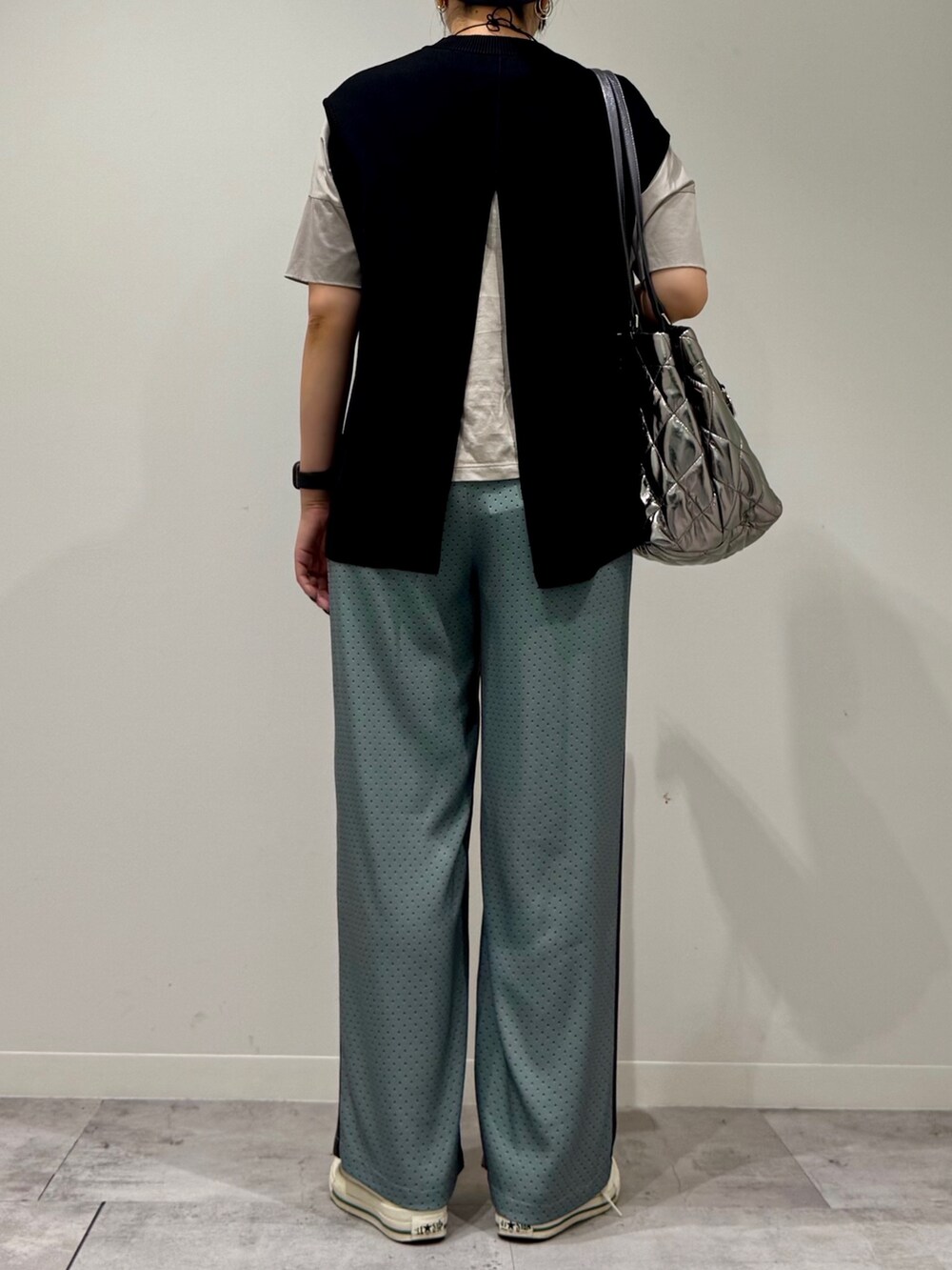 シルバー系のトートバッグ、ベージュ系のその他パンツ、ブラック系のベストを着用したレディースの秋コーディネートの3枚目の写真