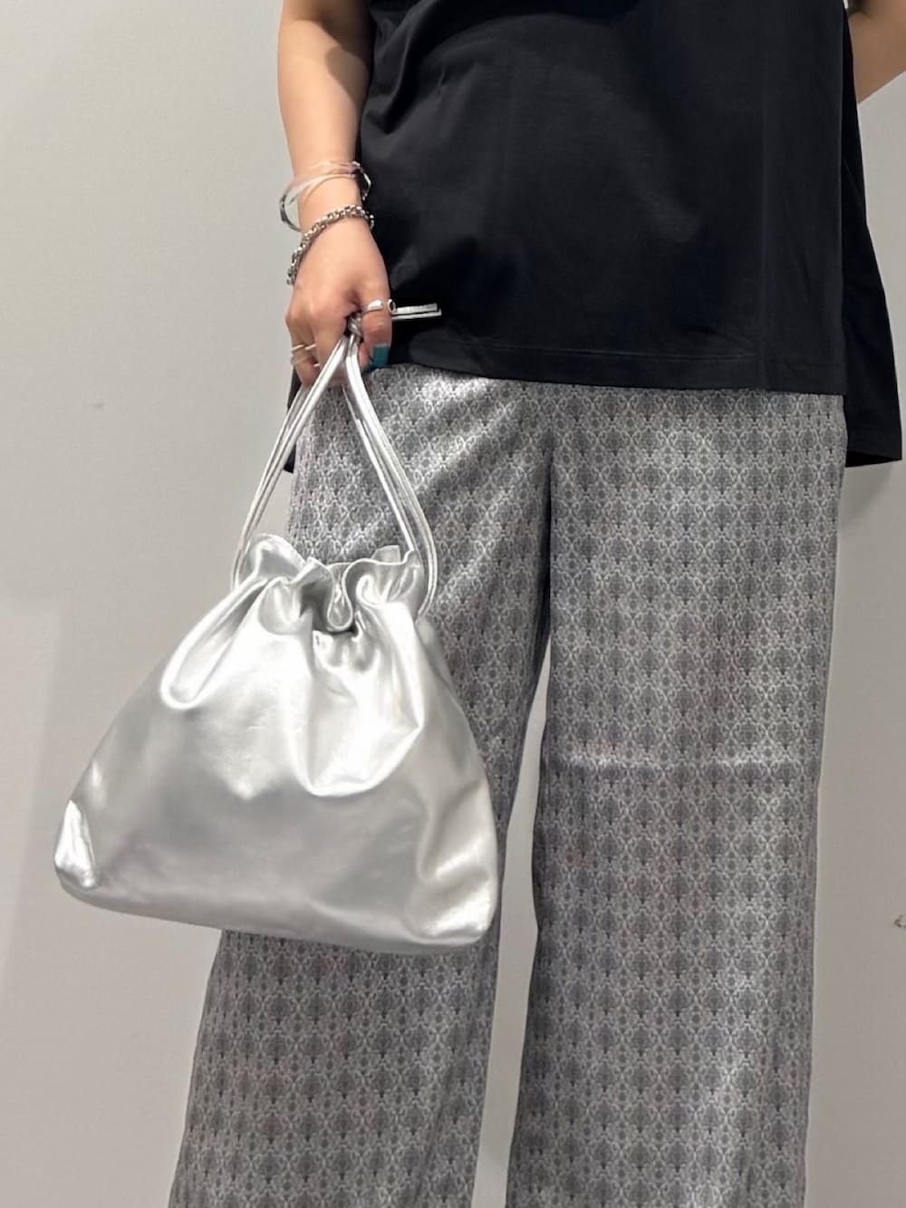 シルバー系のショルダーバッグ、グレー系のTシャツ/カットソー、ベージュ系のその他パンツを着用したレディースの秋コーディネートの9枚目の写真