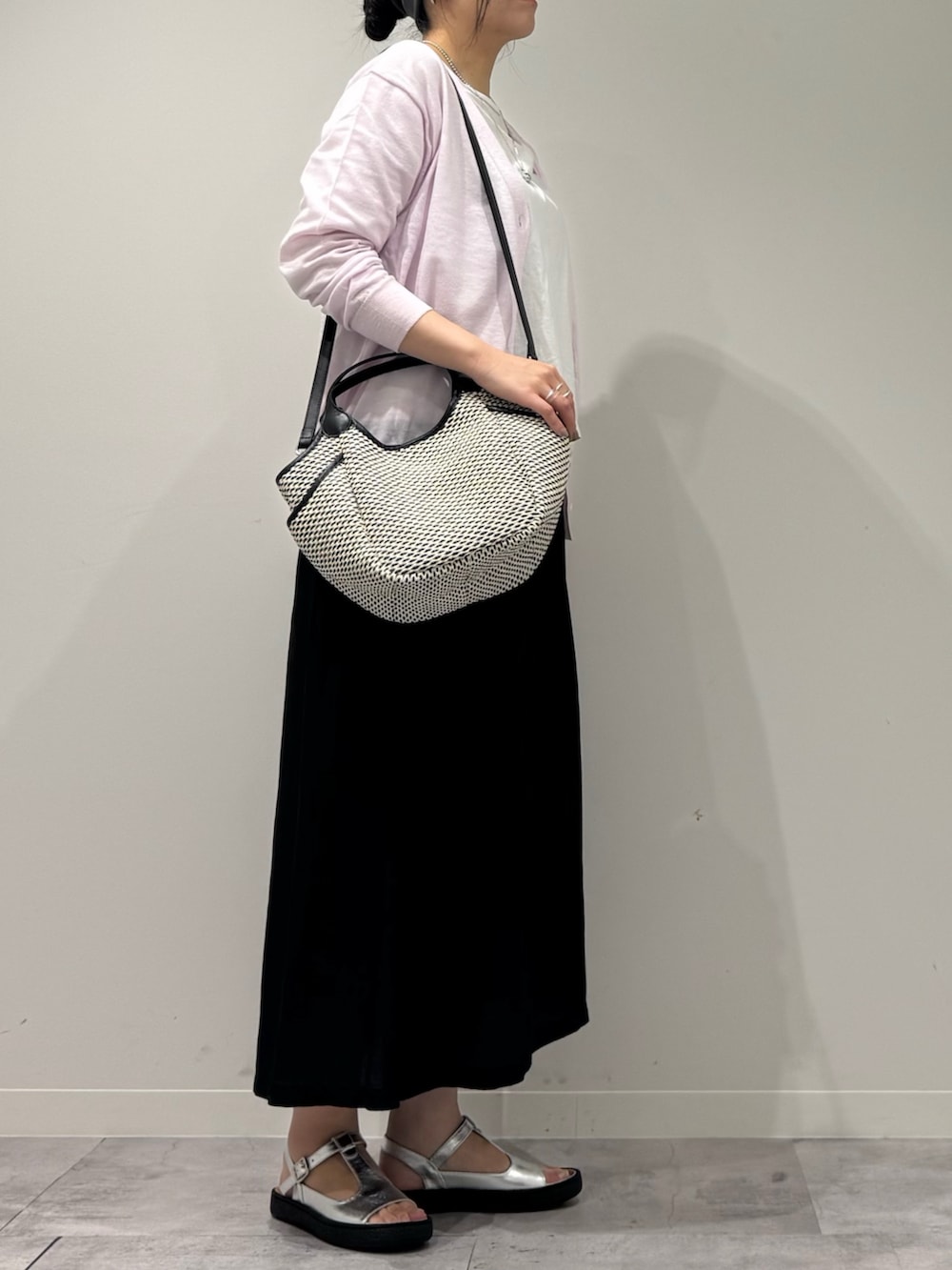 ブラック系のかごバッグ、ピンク系のカーディガン/ボレロ、ホワイト系のTシャツ/カットソーを着用したレディースの春コーディネートの7枚目の写真