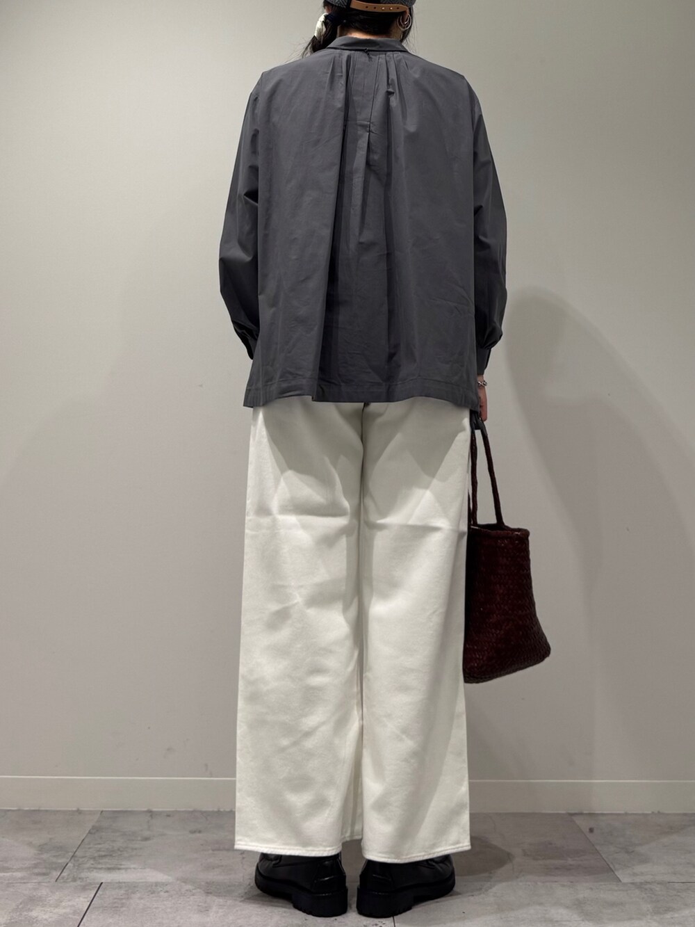 ブラウン系のトートバッグ、ホワイト系のデニムパンツ、ブラック系のローファーを着用したレディースの秋コーディネートの3枚目の写真