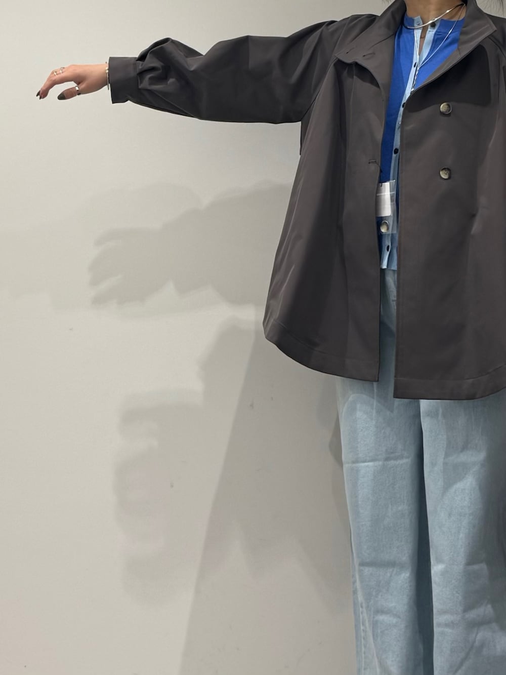 グレー系のトレンチコート、ブラック系のボストンバッグ、ブルー系のデニムパンツを着用したレディースの冬コーディネートの6枚目の写真