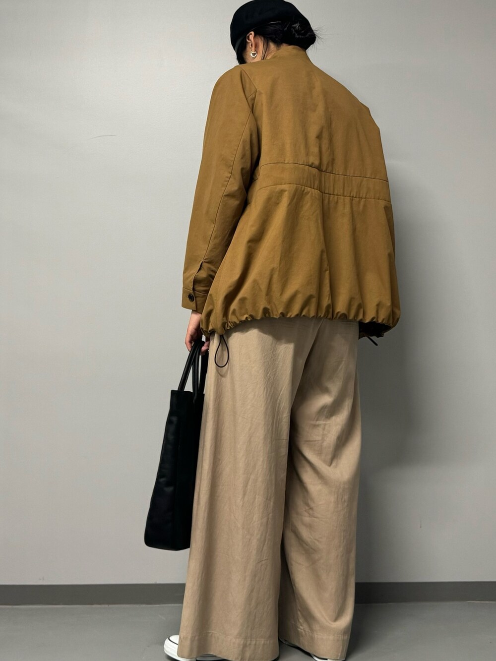 ブラック系のトートバッグ、ベージュ系のブルゾン、ブラック系のTシャツ/カットソーを着用したレディースの秋コーディネートの5枚目の写真