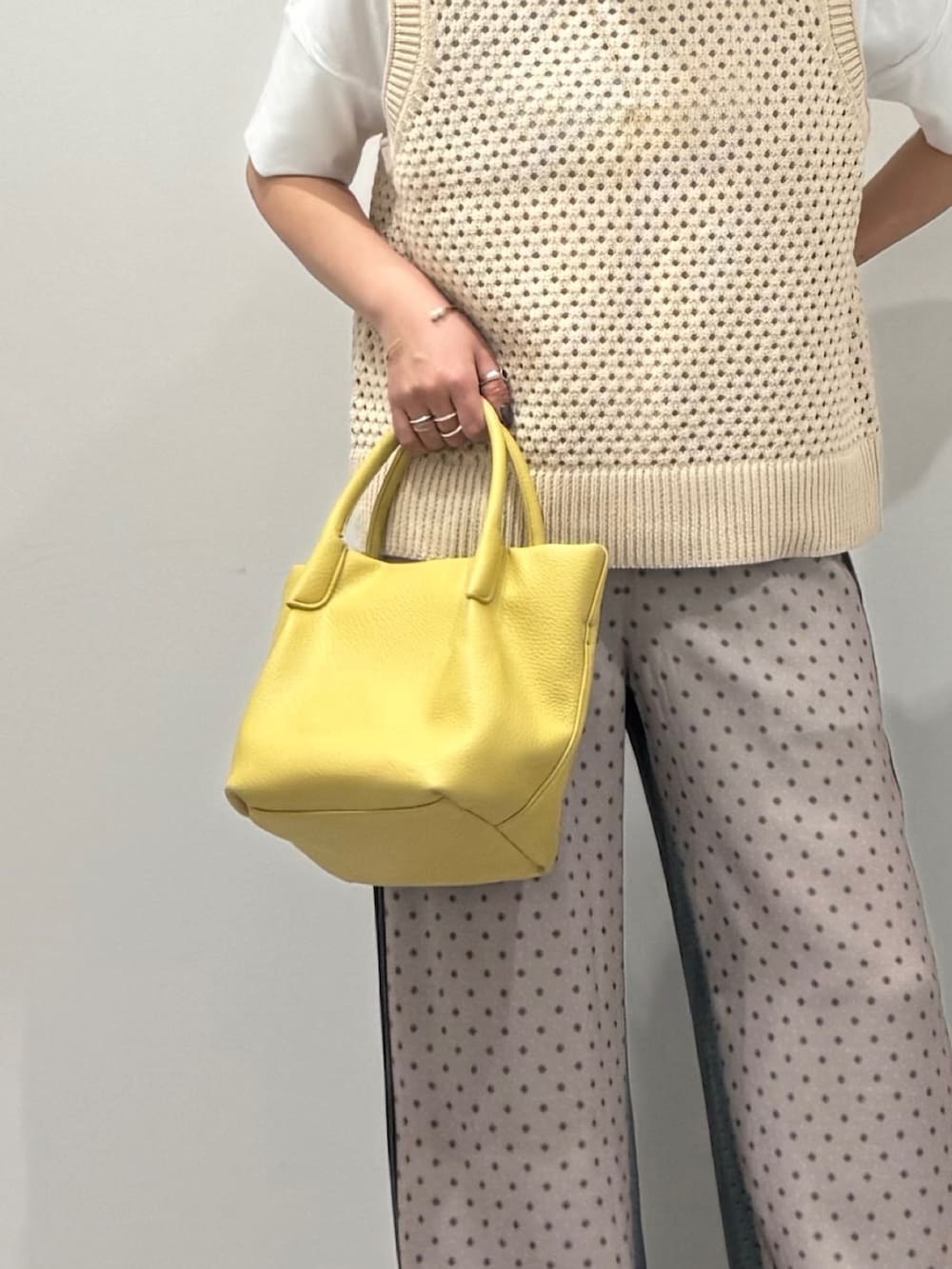 イエロー系のショルダーバッグ、ベージュ系のその他パンツ、ブラック系のローファーを着用したレディースの春コーディネートの7枚目の写真