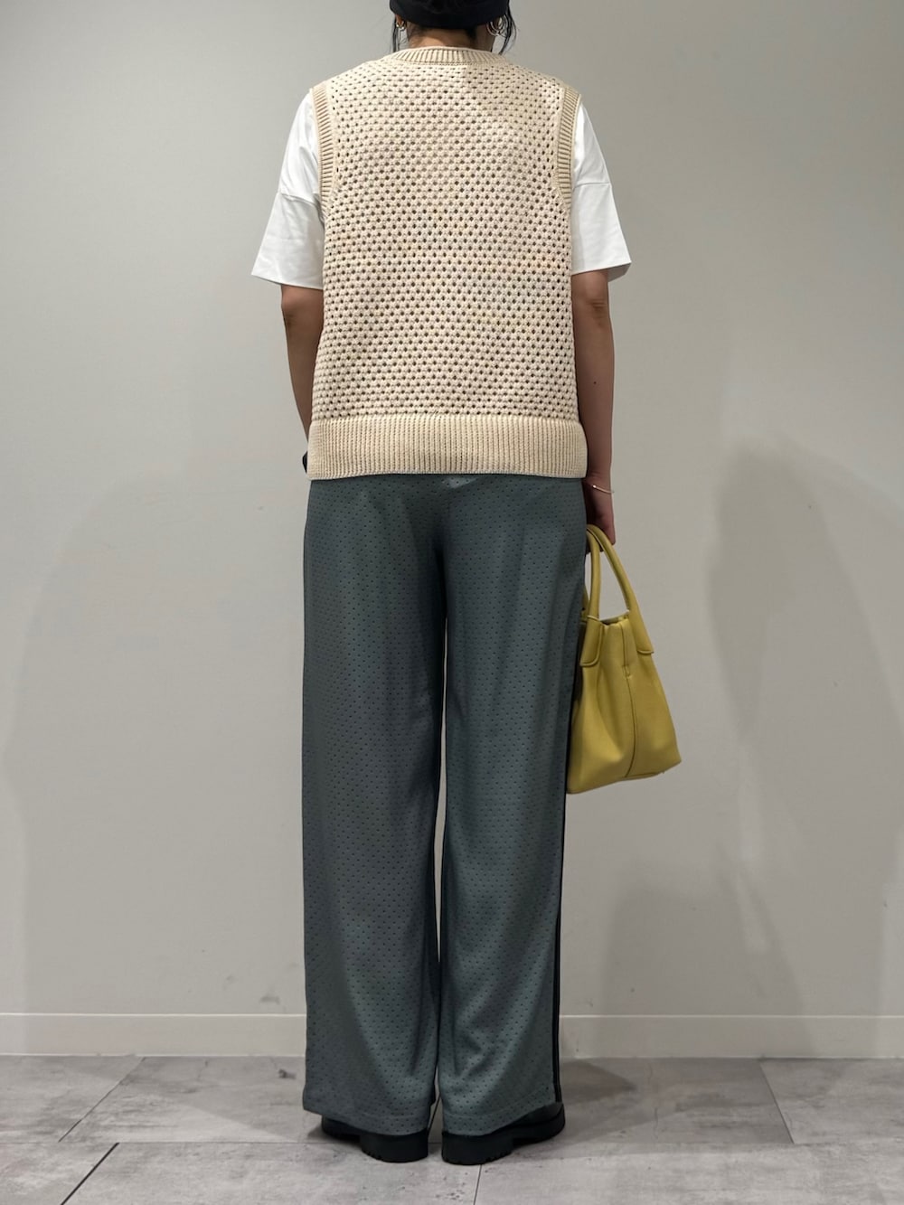 イエロー系のショルダーバッグ、ベージュ系のその他パンツ、ブラック系のローファーを着用したレディースの春コーディネートの3枚目の写真